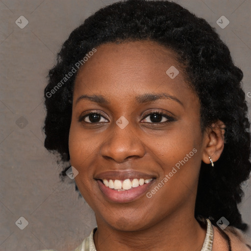 Joyful black young-adult female with long  black hair and brown eyes