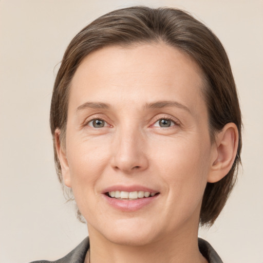 Joyful white adult female with medium  brown hair and grey eyes