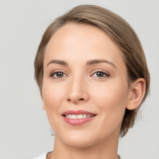 Joyful white young-adult female with medium  brown hair and grey eyes