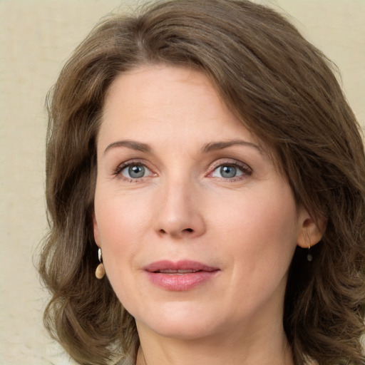 Joyful white adult female with medium  brown hair and green eyes