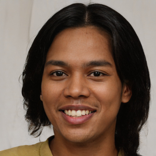Joyful latino young-adult male with medium  brown hair and brown eyes