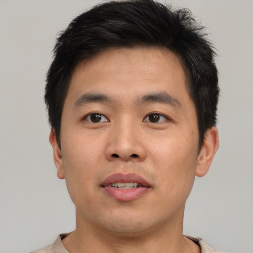 Joyful asian young-adult male with short  brown hair and brown eyes