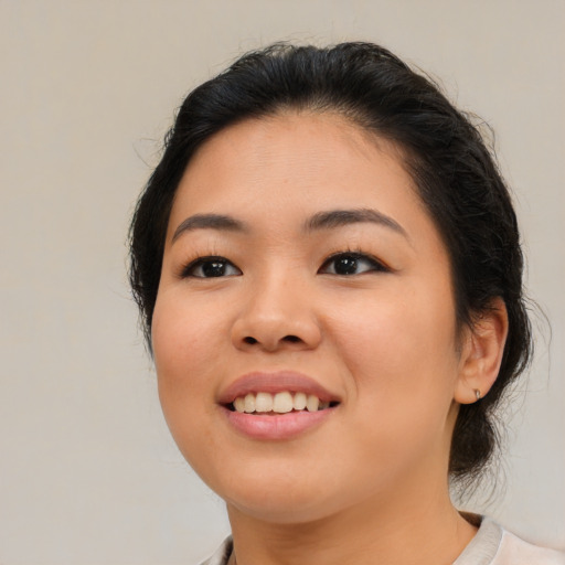 Joyful asian young-adult female with medium  black hair and brown eyes
