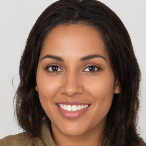 Joyful latino young-adult female with long  brown hair and brown eyes