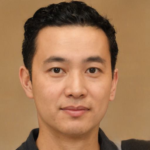 Joyful asian young-adult male with short  black hair and brown eyes