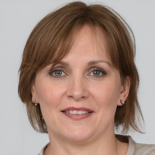 Joyful white adult female with medium  brown hair and grey eyes