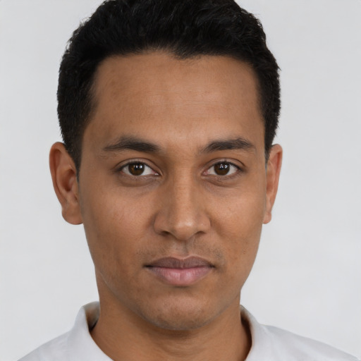 Joyful latino young-adult male with short  black hair and brown eyes