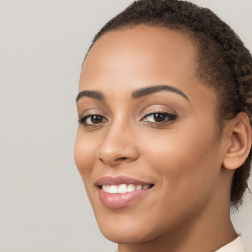 Joyful latino young-adult female with medium  brown hair and brown eyes