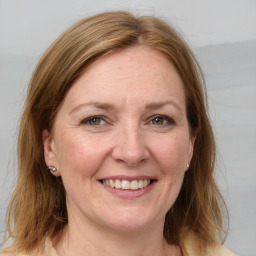 Joyful white adult female with medium  brown hair and grey eyes