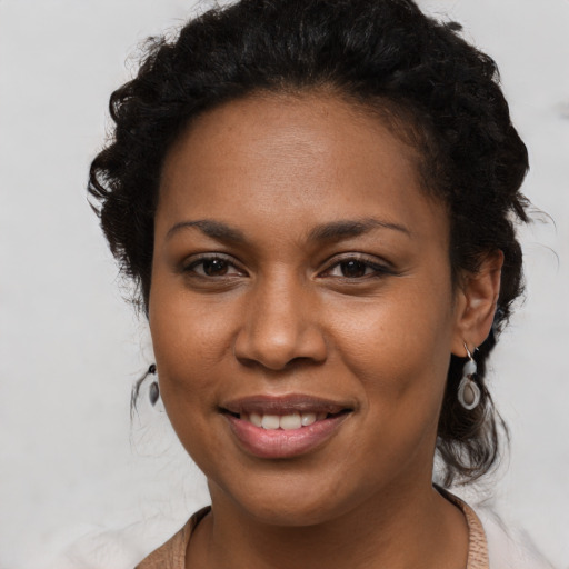 Joyful black young-adult female with long  brown hair and brown eyes