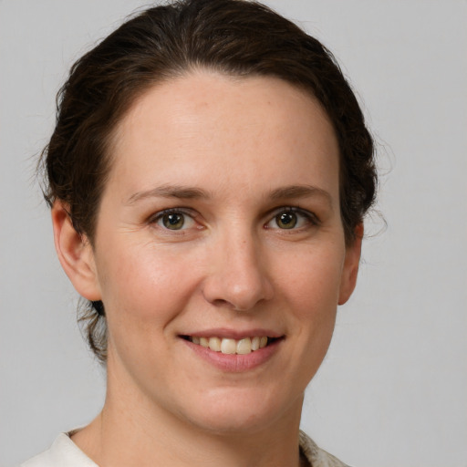 Joyful white young-adult female with medium  brown hair and grey eyes