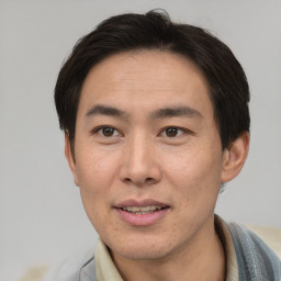 Joyful asian adult male with short  brown hair and brown eyes