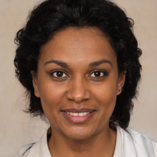 Joyful black young-adult female with medium  brown hair and brown eyes