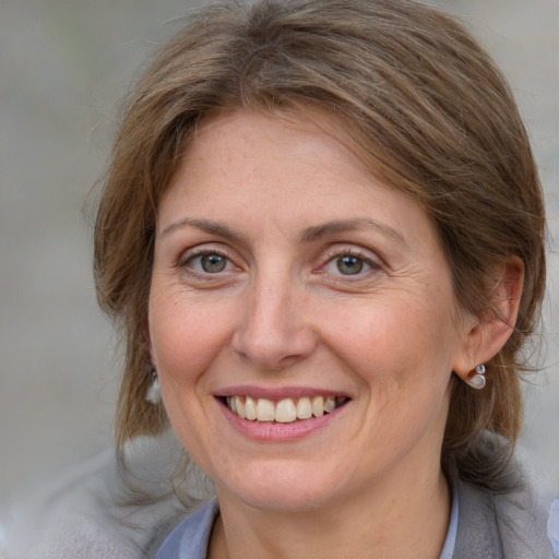 Joyful white adult female with medium  brown hair and blue eyes