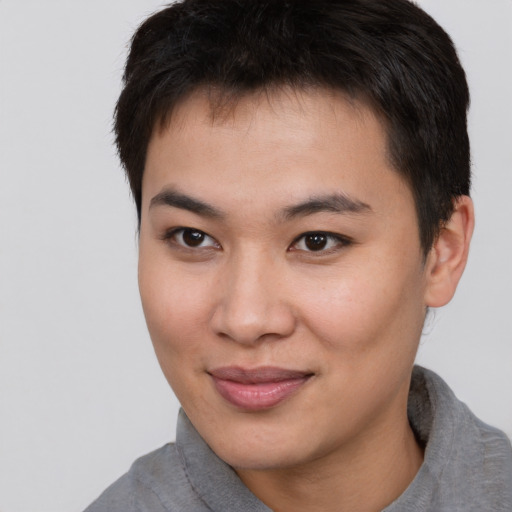 Joyful asian young-adult male with short  brown hair and brown eyes