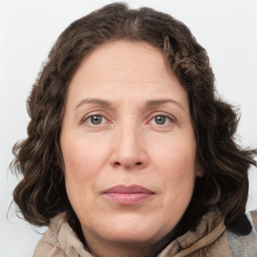 Joyful white adult female with medium  brown hair and green eyes