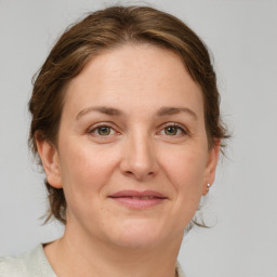 Joyful white adult female with medium  brown hair and green eyes