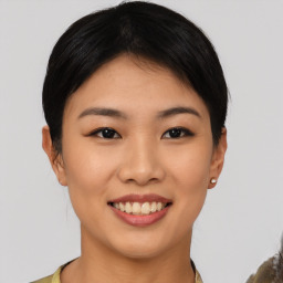 Joyful asian young-adult female with short  brown hair and brown eyes