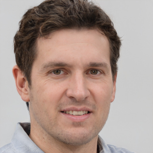 Joyful white adult male with short  brown hair and grey eyes