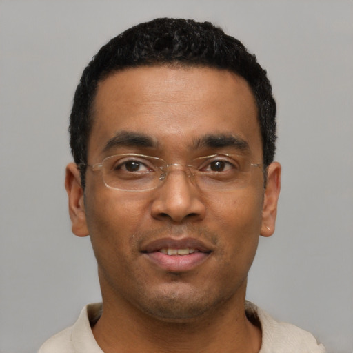 Joyful black young-adult male with short  black hair and brown eyes