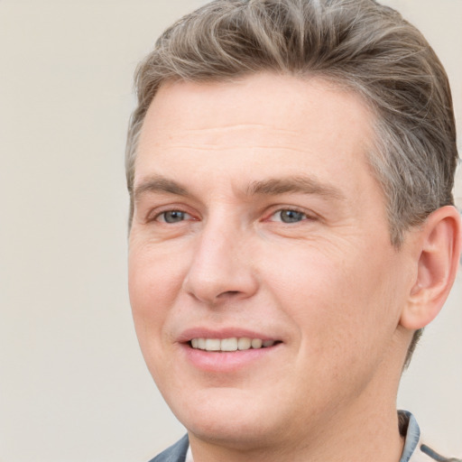 Joyful white adult male with short  brown hair and grey eyes