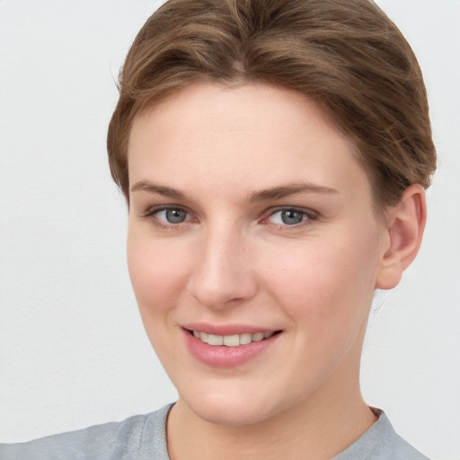 Joyful white young-adult female with short  brown hair and grey eyes