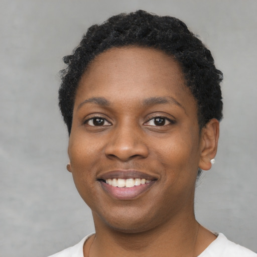 Joyful black young-adult female with short  black hair and brown eyes