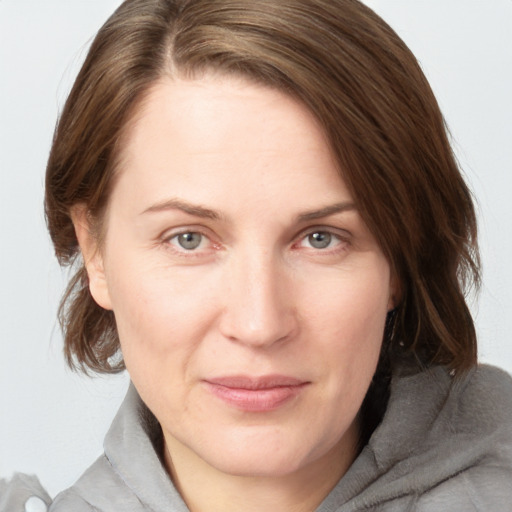 Joyful white young-adult female with medium  brown hair and grey eyes