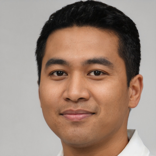 Joyful latino young-adult male with short  black hair and brown eyes