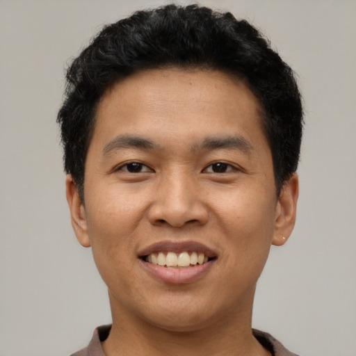 Joyful asian young-adult male with short  black hair and brown eyes