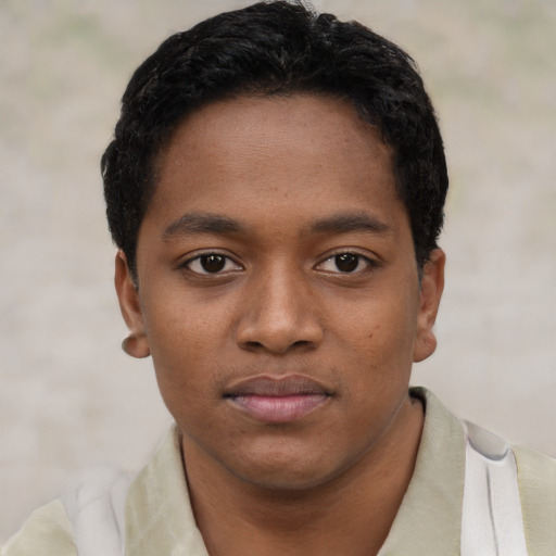 Joyful black young-adult male with short  black hair and brown eyes