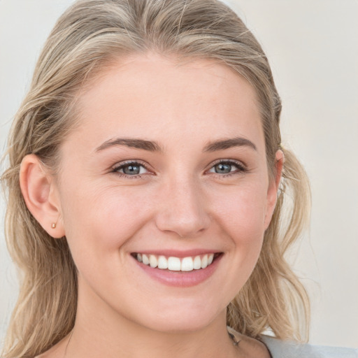 Joyful white young-adult female with long  brown hair and blue eyes