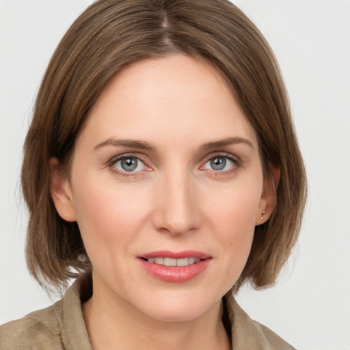 Joyful white young-adult female with medium  brown hair and grey eyes