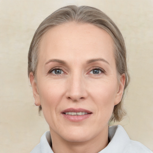 Joyful white adult female with medium  brown hair and grey eyes