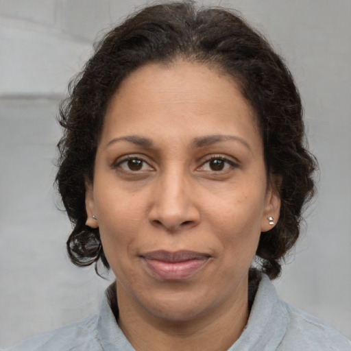 Joyful latino adult female with medium  brown hair and brown eyes