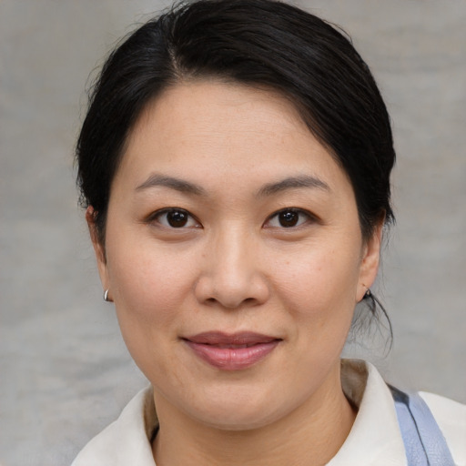 Joyful asian adult female with medium  brown hair and brown eyes