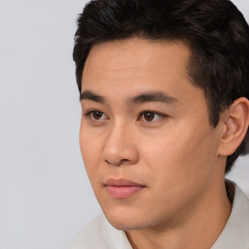 Joyful asian young-adult male with short  black hair and brown eyes