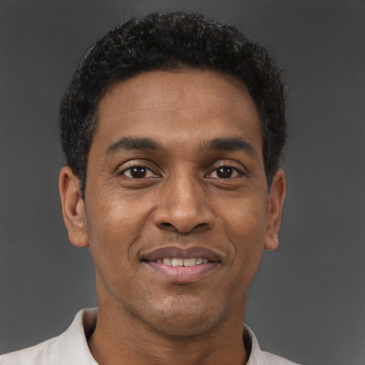 Joyful black young-adult male with short  brown hair and brown eyes