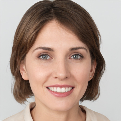 Joyful white young-adult female with medium  brown hair and grey eyes