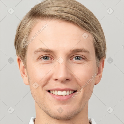 Joyful white young-adult male with short  brown hair and grey eyes