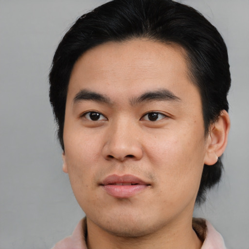 Joyful asian young-adult male with medium  black hair and brown eyes