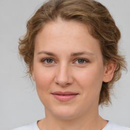 Joyful white young-adult female with medium  brown hair and green eyes