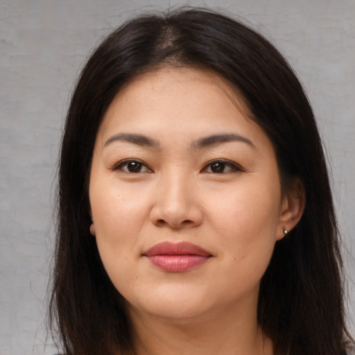 Joyful asian young-adult female with long  brown hair and brown eyes