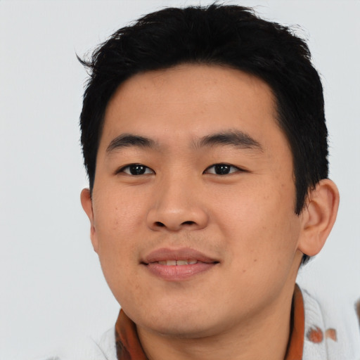 Joyful asian young-adult male with short  black hair and brown eyes