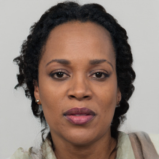 Joyful black adult female with short  black hair and brown eyes