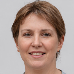 Joyful white adult female with medium  brown hair and grey eyes