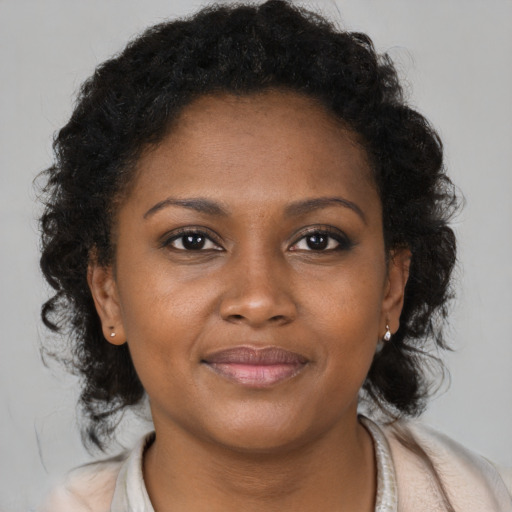 Joyful black young-adult female with long  brown hair and brown eyes