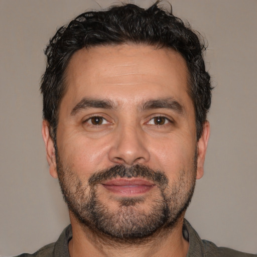 Joyful white adult male with short  black hair and brown eyes