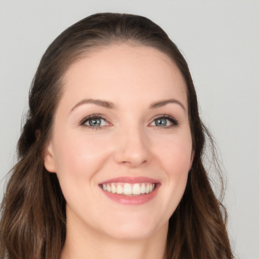 Joyful white young-adult female with long  brown hair and grey eyes