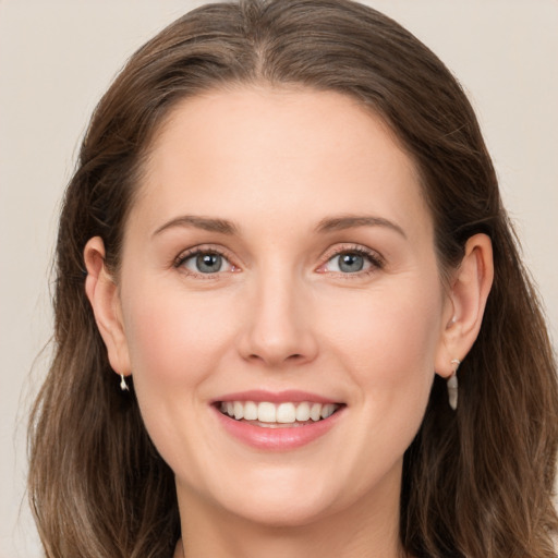 Joyful white young-adult female with long  brown hair and grey eyes